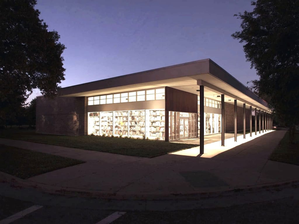 Dusk rendering of Dearborn Commons, a branch library and neighborhood hall under one roof with a long covered porch.